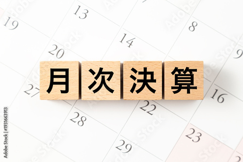 「月次決算」と書かれたブロックとカレンダー