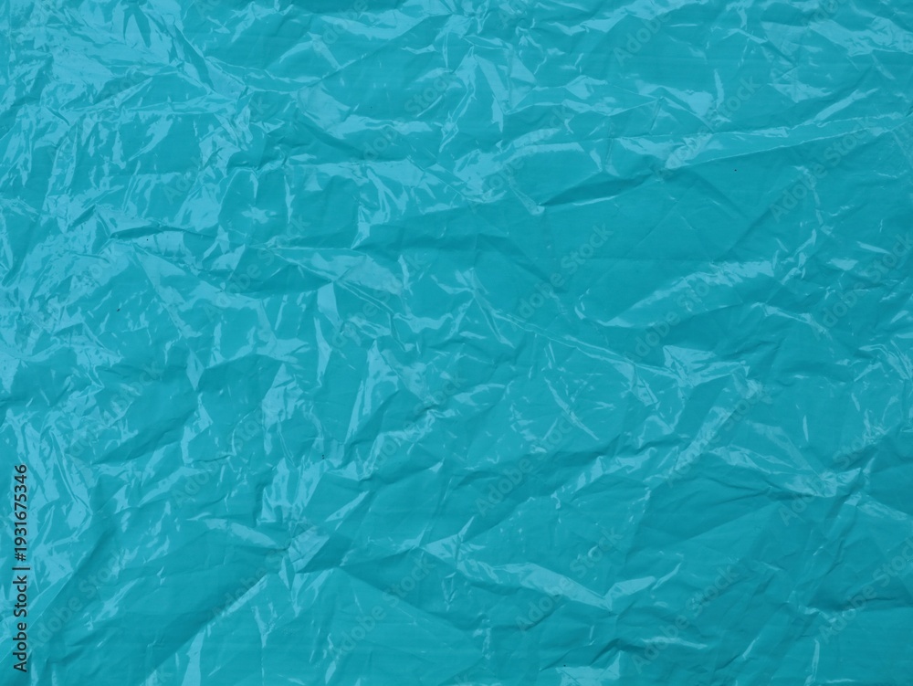 Fototapeta premium Crumpled teal blue plastic texture background. Perfect for creative backgrounds, waste management concepts, or industrial textures