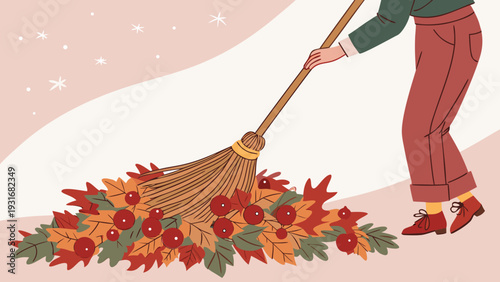 Person sweeping autumn leaves with a broom in a cozy outdoor setting.