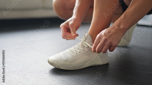 Person tying white sport shoes getting ready for workout