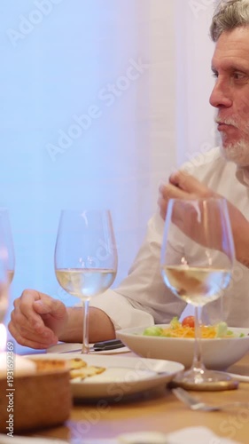Mature friends enjoying a festive dinner party at home