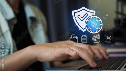 Business professional using laptop with cybersecurity protection interface featuring shield icon, biometric fingerprint  data management system for privacy compliance digital security.