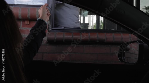 Woman driving up to toll booth to pay in Colombia, South America.