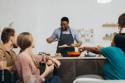 Canvas-taulu Friends cooking together making dinner celebrating camaraderie