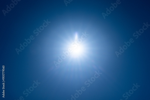 Фотография 青空に輝く太陽、映り込むフレア