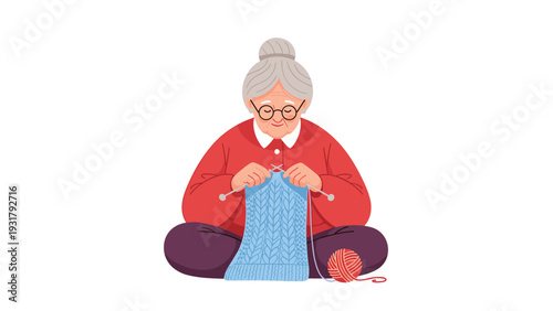 Sweet older woman with glasses and gray hair, sitting cross-legged and peacefully knitting a blue garment, illustrating a calming and productive hobby.