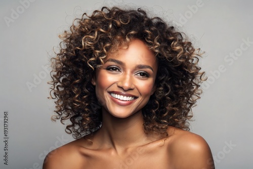 Smiling woman with curly brown and blonde highlighted hair