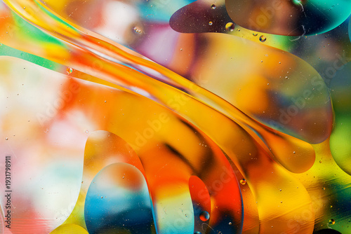 Close-up of the movement of oil droplets on the water surface. Colorful abstract macro background of oil drops on the water surface.