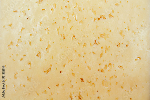 Fotografie A detailed texture of swiss cheese with large holes for gourmet backgrounds and