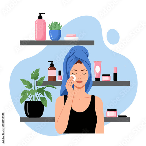 Woman with blue towel on head applying skincare product to her face in a bathroom setting.