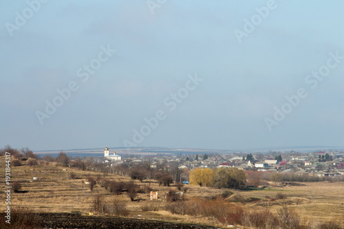 A landscape with a town and a church in the distance