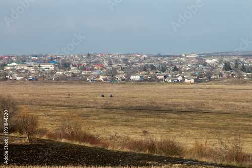 A field with houses in the background