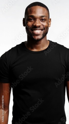 Man walks away on white background and turns toward viewer smiling. Adult male faces camera as it moves closer during approach. Confidence expression and personal connection concept..
