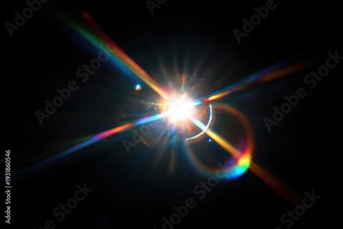 Vibrant lens flare with colorful light rays on a dark background.