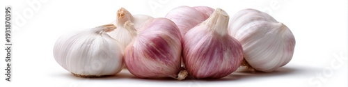 Garlic bulbs grouped together showing papery skins on white background