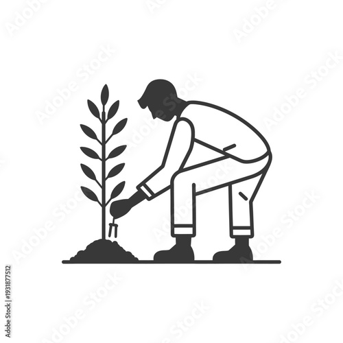 A Person Planting a Sapling with a Hand Tool