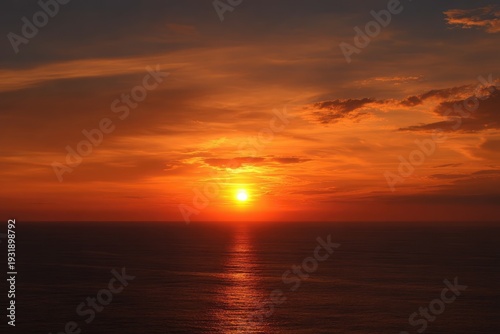 Vibrant Orange Sunset Over Calm Ocean Waters with Reflective Glow.