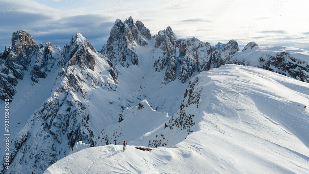Fototapeta premium Beautiful Winter Dolomite Mountain Scenery with Man on Cross-Country Skis , Aerial View