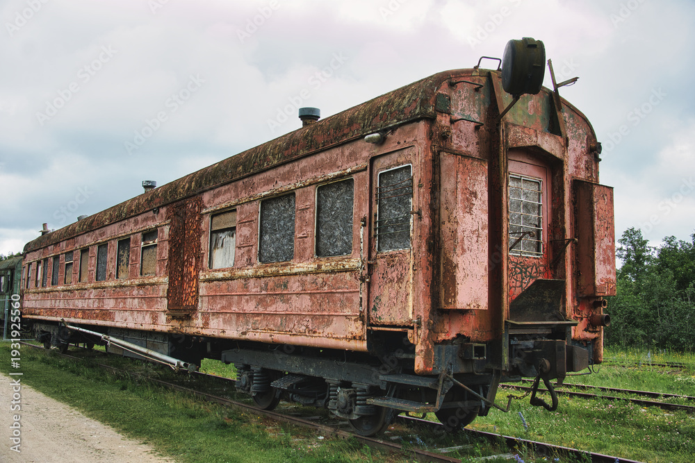 Fototapeta premium Abandoned Vintage Rusty Train Carriage on Overgrown Tracks
