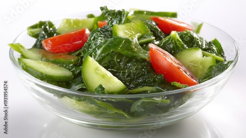 A refreshing bowl of crisp leafy spinach and kale greens tossed with fresh cucumber and tomato slices