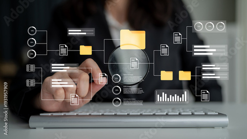 Tableau sur toile A business professional uses a magnifying glass to analyze digital data and organize files, showcasing a modern approach to research and information management