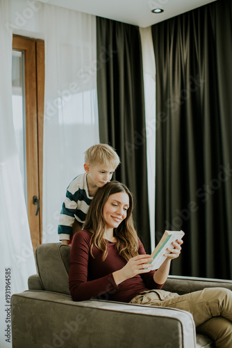 Woman reads book while boy ...
