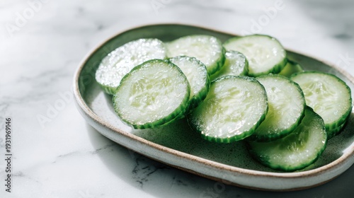 Freshly sliced cucumber rounds artfully arranged on an elegant oval plate, showcasing vibrant green and refreshing textures.
