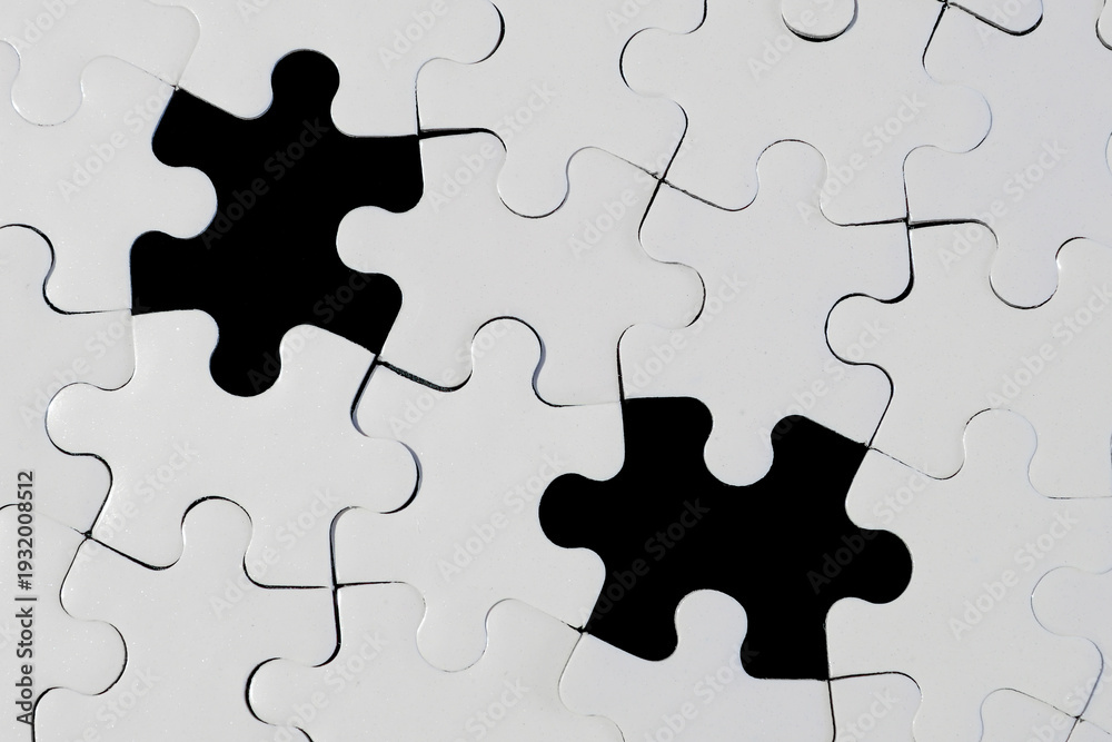 Fototapeta premium White Jigsaw Puzzle with Two Missing Pieces on Black Background