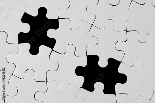 White Jigsaw Puzzle with Two Missing Pieces on Black Background