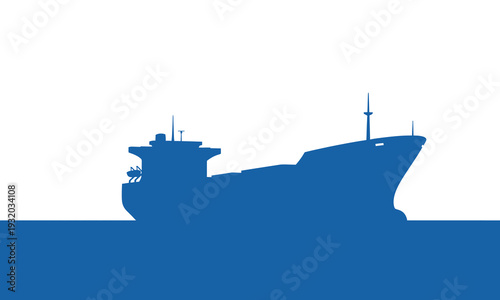 Silhouette of a large cargo ship sailing on the ocean at sunrise