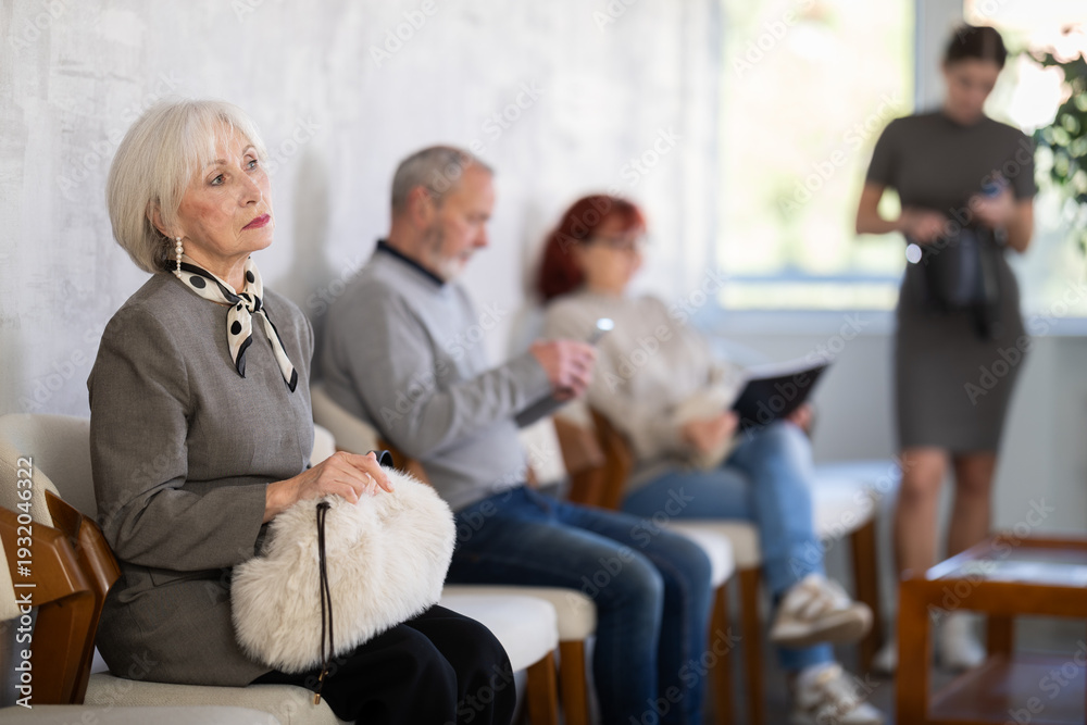 Obraz premium Elderly man and woman in casual clothes waiting for his turn on chair in reception