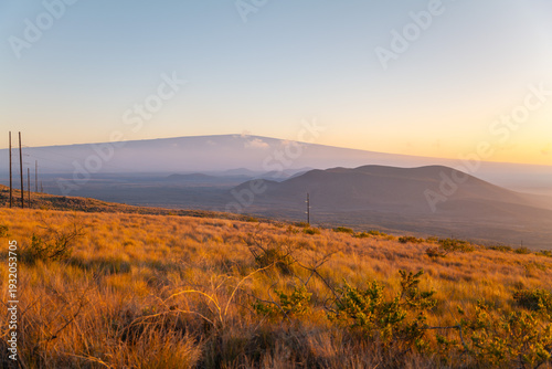 In the distance is the Mauna Kea (Shield volcano). near Kilohana Hunter Check-in Station and Waiki'i Ranch , Saddle Road, The Big Island (Hawaiʻi Island). Sunset. cinder cone or scoria cone