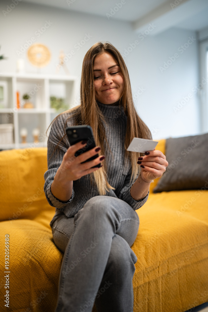 Obraz premium Young woman shopping online using phone and credit card