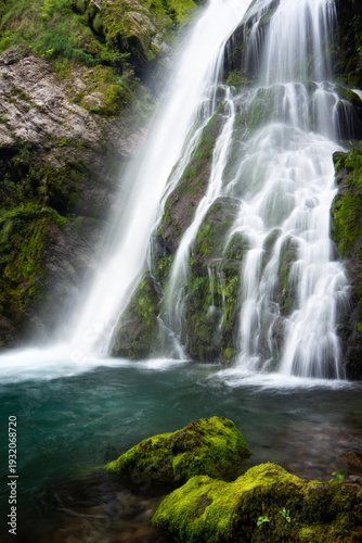 Long‑Exposure Waterfall Flowing Over Mossy Rocks in a Forest with Soft Light and Natural Atmosphere