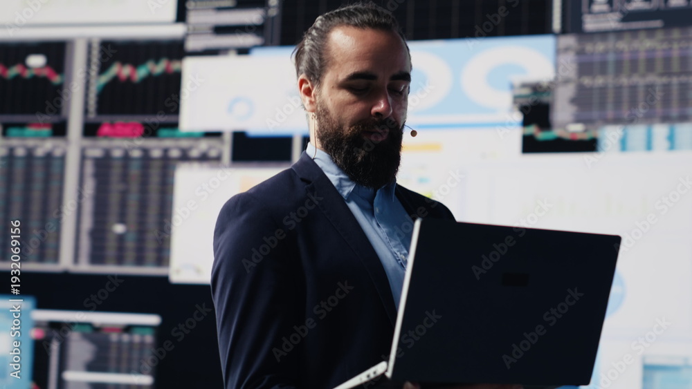 Fototapeta premium Male public speaker and business coach leading a dynamic presentation with a live audience. Sharing strategy, growth ideas and financial forecasting in a tech driven business event. Camera A.