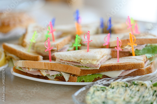 Obraz na płótnie Assorted sandwiches with colorful picks on a serving platter