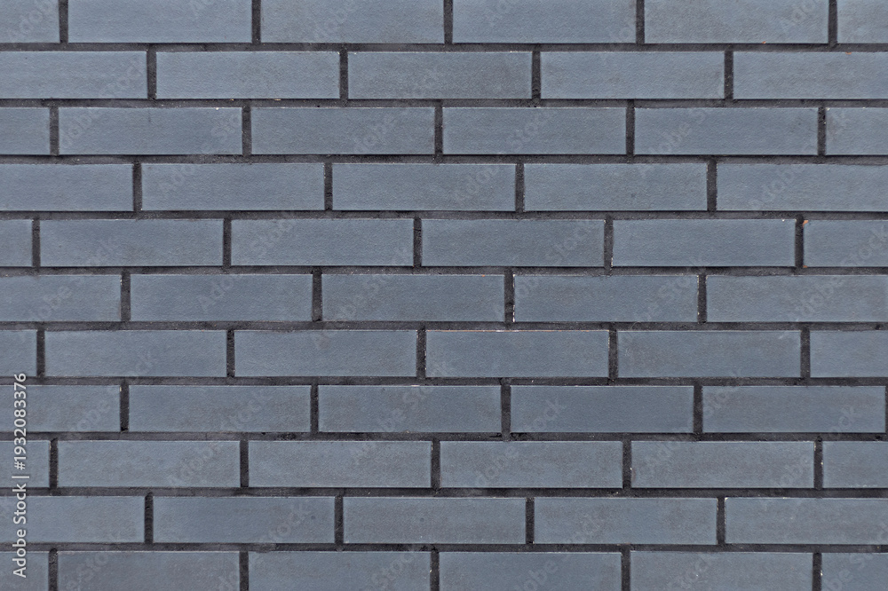 Fototapeta premium Textured grey surface resembling brick masonry, industrial style backdrop