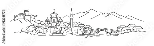 Historic town with domes and bridge by river and hills