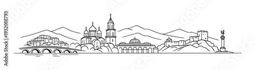 City skyline with churches and towers by waterfront and mountains