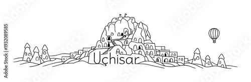 Uchisar castle formation with buildings and hot air balloon