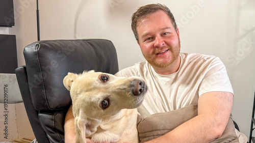 Photos Gentleman with soulful Labrador, joyfully nestled, echoes of National Pet Day an