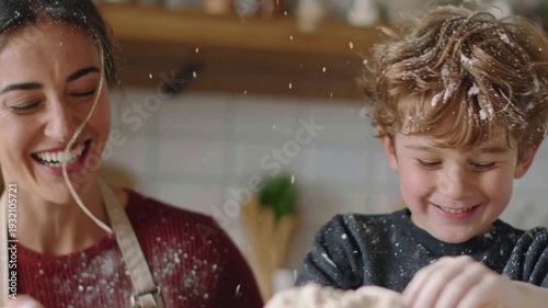 A happy mother and son laughing together in the kitchen while baking a cake