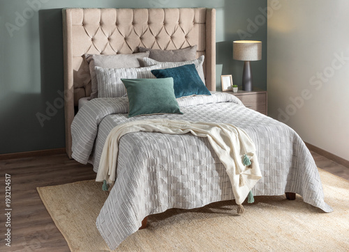 A cozy bed with white pillows, blankets, and colorful accent pillows