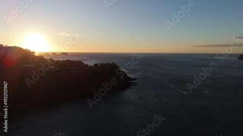 Aerial movement approaching coastal cliff at sunset