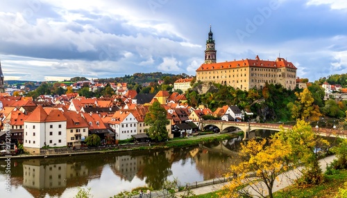 Picturesque medieval town with red-roofed buildings, a castle, and river reflection