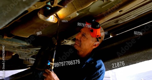 Mechanic lighting torch, heating exhaust on lift for repair, floating numeric text tracking temp