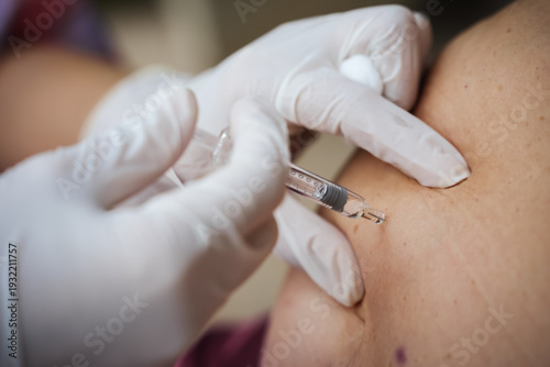 close up doctor is injecting enoxaparin injection to belly with syringe