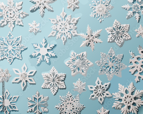 An overhead view of intricately cut paper snowflakes on a blue background
