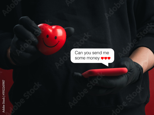 Scammer holding red heart and smartphone with message asking for money. Online romance scam, phishing fraud, manipulating love for gain, social engineering attack and digital financial crime concept.