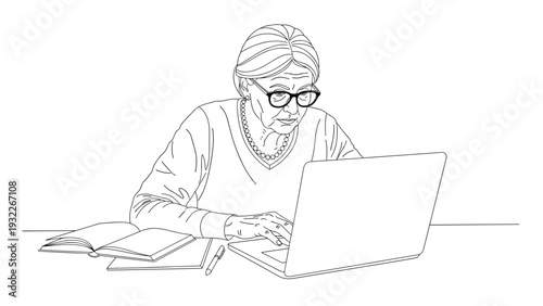 Focused elderly woman with grey hair wearing glasses works diligently on her laptop at a desk with an open book and pen.